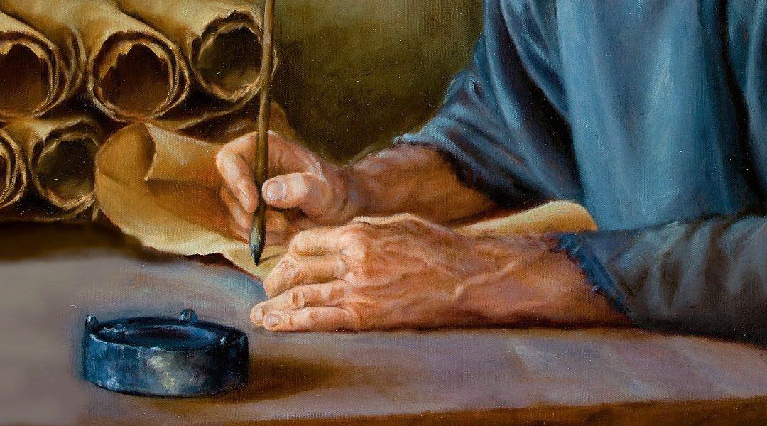 Manos de Pablo u hombre de la antigüedad escribiendo con una pluma en un rollo de papiro